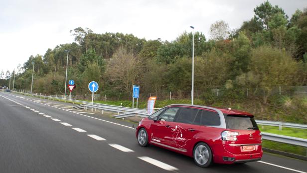 Ein roter Citroën fährt auf einer Autobahn mit dem Schriftzug „Autonomous Driving“.