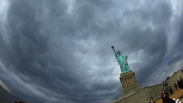 Die Freiheitsstatue vor einem dramatischen, dunklen Himmel.
