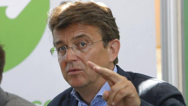 Ein Mann mit Brille gestikuliert mit erhobenem Zeigefinger.