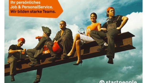 Fünf Personen sitzen auf einem Stahlträger vor einem bewölkten Himmel.