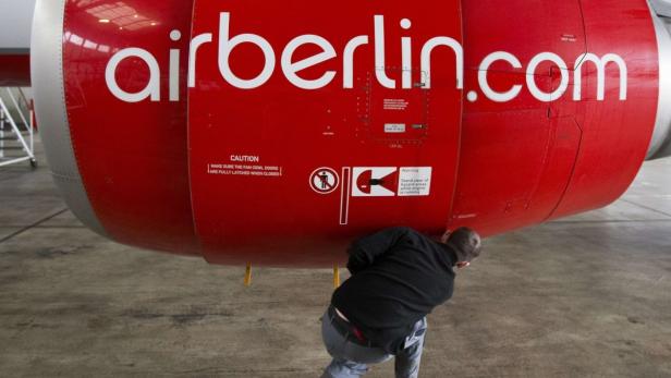 An Air Berlin technician opens the cover of a jet engine of an Air Berlin plane at a hangar at Tegel Airport in Berlin, January 16, 2013. German airline Air Berlin , part-owned by Abu Dhabi-based carrier Etihad, plans to cut almost 10 percent of its workforce of 9,300 as part of a cost-cutting campaign aimed at halting years of losses. REUTERS/Thomas Peter (GERMANY - Tags: TRANSPORT BUSINESS)