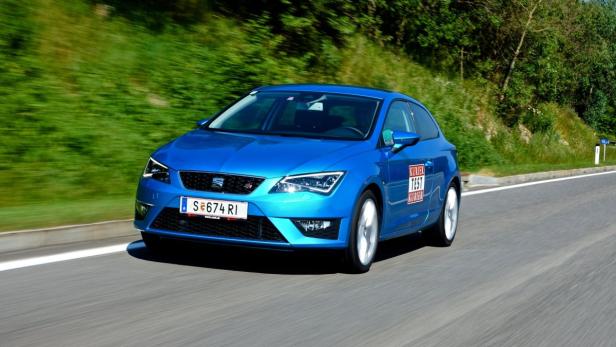 Ein blauer Seat Leon fährt auf einer Landstraße.