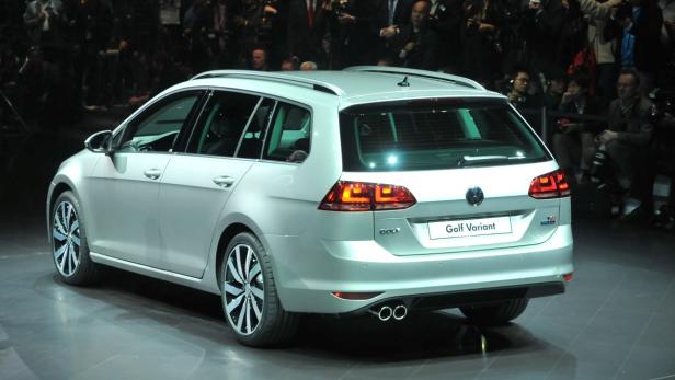 Ein silberner VW Golf Variant steht auf einer Bühne vor Publikum.