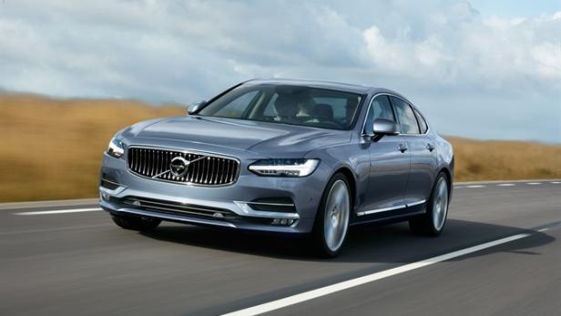 Ein grauer Volvo S90 fährt auf einer Landstraße.