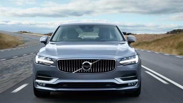 Ein grauer Volvo S90 fährt auf einer Landstraße.
