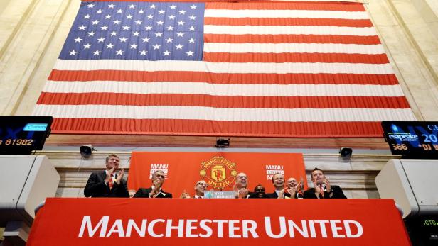 epa03354927 Executives of the Manchester United, including owners Joel Glazer (3-L) and Avram Glazer (4-L), and CEO David Gill (L) clap during the Opening Bell and to celebrate the initial public offering of shares of Manchester United on the floor of the New York Stock Exchange in New York City, New York, USA, 10 August 2012. Shares in English football giant Manchester United found fewer fans than hoped on the New York Stock Exchange 10 August, where its share price traded at 14.05 dollars, just a few cents higher than that of its float price. The club was forced to drop its initial public offering price on 09 August to 14 dollars, significantly lower than the 16-dollar to 20-dollar price range it had originally outlined. The club is considered the most valuable sports franchise in the world, according to Forbes magazine, and is supported by about 660 million fans worldwide. EPA/JUSTIN LANE