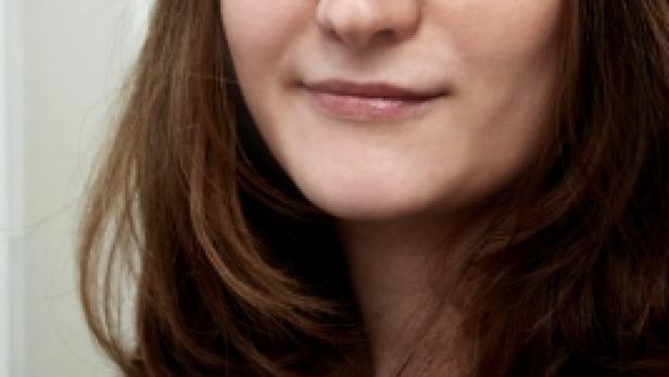 Porträt einer Frau mit langen, gewellten braunen Haaren.