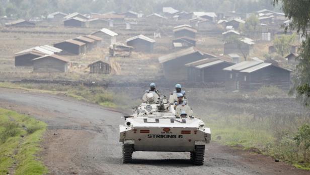 U.N. peacekeepers patrol in their tank, past the d