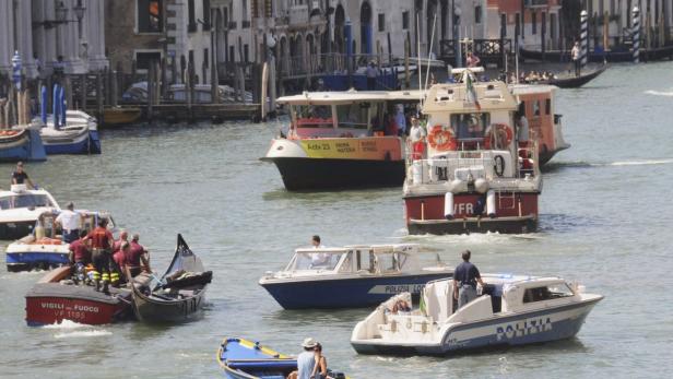 Firefighters (L) transport a gondola after it crashed with a ferry boat at the Grand Canal in Venice August 17, 2013. The accident resulted in the death of a German tourist, with other passengers injured, reported local media. REUTERS/Manuel Silvestri (ITALY - Tags: TRAVEL MARITIME DISASTER)