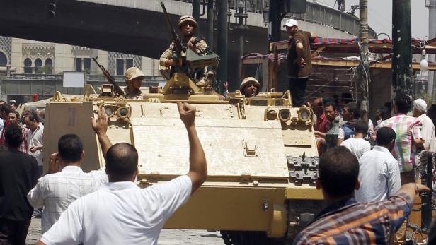 Supporters of the interim government installed by the army cheer as an army armoured personnel carrier (APC) moves into position near the al-Fath mosque on Ramses Square in Cairo August 17, 2013. Egyptian authorities rounded up more than 1,000 Islamists as the Muslim Brotherhood leadership defiantly called a week of nationwide protests starting on Saturday after a day of carnage. REUTERS/Amr Abdallah Dalsh (EGYPT - Tags: POLITICS CIVIL UNREST MILITARY)
