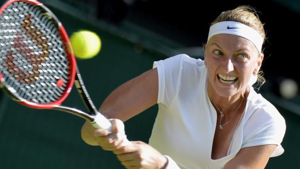 Eine Tennisspielerin schlägt einen Ball mit ihrem Schläger.