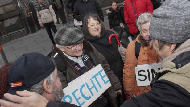 Eine Gruppe von Menschen demonstriert mit Schildern in der Hand.