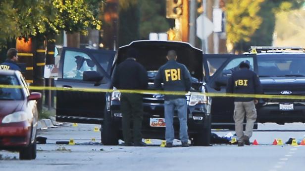 FBI und Polizei untersuchen, den Wagen, in dem die mutmaßlichen Täter erschossen wurden.