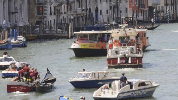 Firefighters (L) transport a gondola after it crashed with a ferry boat at the Grand Canal in Venice August 17, 2013. The accident resulted in the death of a German tourist, with other passengers injured, reported local media. REUTERS/Manuel Silvestri (ITALY - Tags: TRAVEL MARITIME DISASTER)