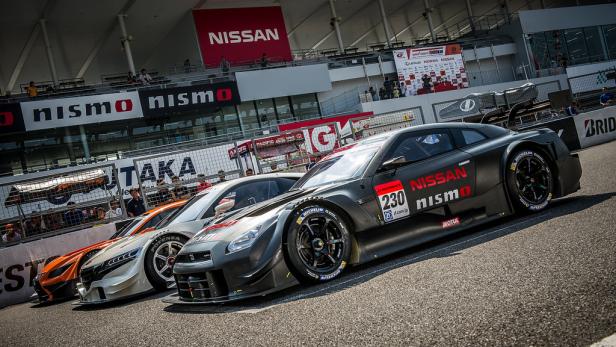 Mehrere Nissan-Rennwagen stehen auf einer Rennstrecke.