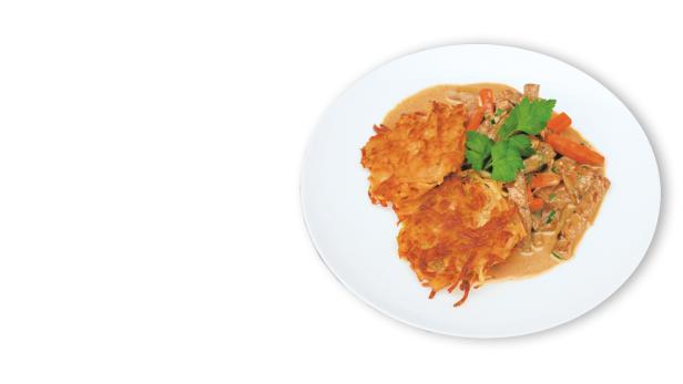 Auf einem Teller liegen Kartoffelpuffer mit Geschnetzeltem und Petersilie.