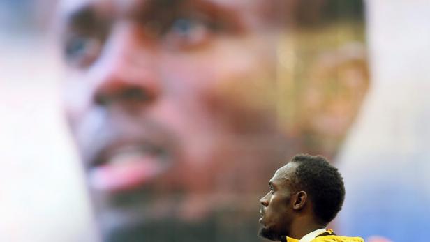 Usain Bolt steht vor einem großen Porträt von sich selbst.