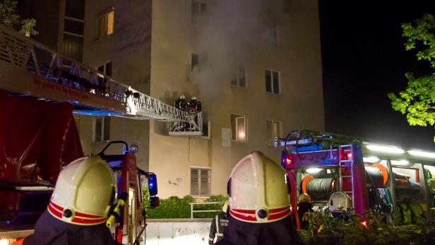 Einsatzkräfte vor dem brennenden Wohnhaus in Salzburg.
