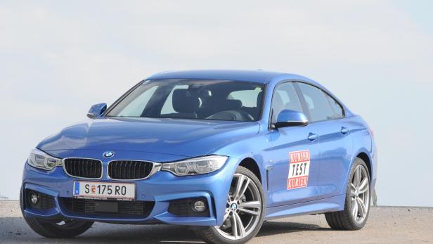 Ein blauer BMW 4er steht auf einem Parkplatz.