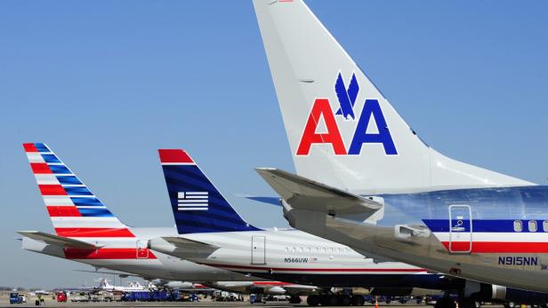 Mehrere Flugzeuge von American Airlines und Aegean Airlines stehen auf einem Rollfeld.