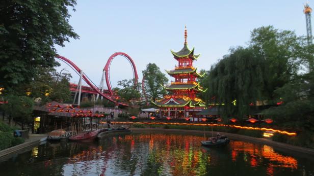 Der beleuchtete chinesische Turm und eine Achterbahn im Tivoli-Garten in Kopenhagen.