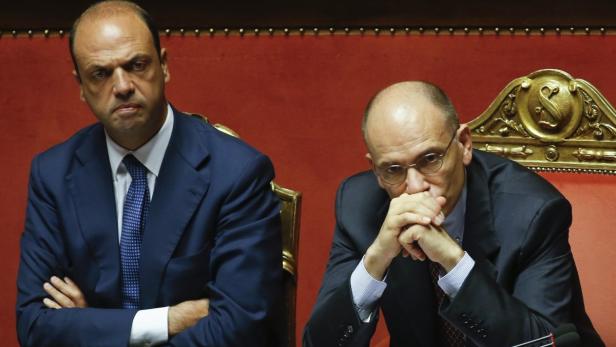 Italy&#039;s Prime Minister Enrico Letta (R) looks on next to Interior minister Angelino Alfano during a vote session at the Senate in Rome July 19, 2013. Alfano survived a no-confidence vote on Friday, averting a political crisis that could have brought down the fragile coalition government of Prime Minister Enrico Letta. Alfano, secretary of Silvio Berlusconi&#039;s centre-right People of Freedom party (PDL) which governs in an uneasy partnership with its traditional rivals in Letta&#039;s centre-left Democratic Party (PD), faced calls to resign over the hurried deportation of the family of a dissident Kazakh oligarch in May. REUTERS/Remo Casilli (ITALY - Tags: POLITICS)