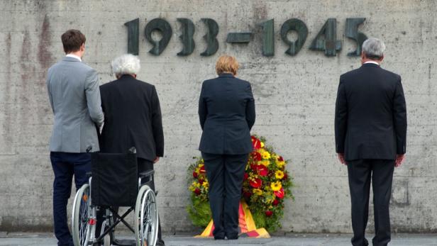 epa03831764 German chancellor Angela Merkel (C), Bavarian Culture Minister Ludwig Spaenle (R) and Holocaust survivor Max Mannheimer (2-L) lay a wreath at the concentration camp memorial in Dachau, Germany, 20 August 2013. Merkel&#039;s visit to the memorial has sparked controversy. She visited the concentration camp quickly between two other election campaign events in Erlangen and Dachau. The German federal elections will be held on 22 September 2013. EPA/INGA KJER