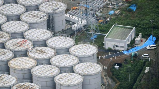 An aerial view shows workers wearing protective suits and masks working atop contaminated water storage tanks at Tokyo Electric Power Co. (TEPCO)&#039;s tsunami-crippled Fukushima Daiichi nuclear power plant in Fukushima, in this photo taken by Kyodo August 20, 2013. Japan&#039;s nuclear watchdog said on Wednesday it is concerned that more storage tanks at the wrecked Fukushima nuclear plant will spring leaks, following the discovery that highly contaminated water is leaking from one of the hastily built containers. Picture taken August 20, 2013. Mandatory Credit. REUTERS/Kyodo (JAPAN - Tags: DISASTER ENVIRONMENT POLITICS ENERGY) ATTENTION EDITORS - THIS IMAGE WAS PROVIDED BY A THIRD PARTY. FOR EDITORIAL USE ONLY. NOT FOR SALE FOR MARKETING OR ADVERTISING CAMPAIGNS. THIS PICTURE IS DISTRIBUTED EXACTLY AS RECEIVED BY REUTERS, AS A SERVICE TO CLIENTS. MANDATORY CREDIT. JAPAN OUT. NO COMMERCIAL OR EDITORIAL SALES IN JAPAN. YES