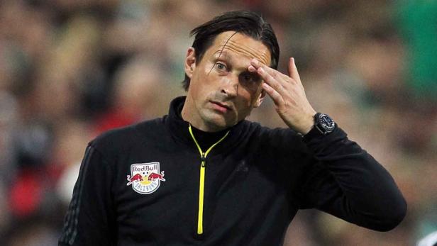 Ein Mann mit einer schwarzen Jacke mit dem Red Bull Salzburg Logo berührt seine Stirn.
