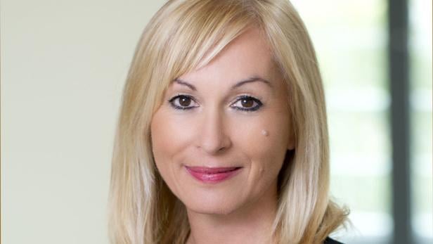 Porträt einer Frau mit blonden, schulterlangen Haaren.