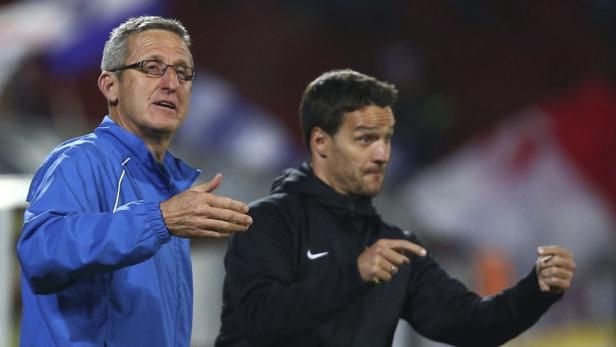 Zwei Männer, vermutlich Trainer, gestikulieren während eines Fußballspiels.