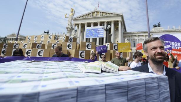 Demonstranten mit Euro-Symbolen und Geldbündeln vor dem österreichischen Parlament.