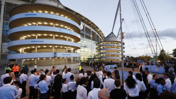 Das Etihad Stadium in Manchester mit einer Menschenmenge davor.