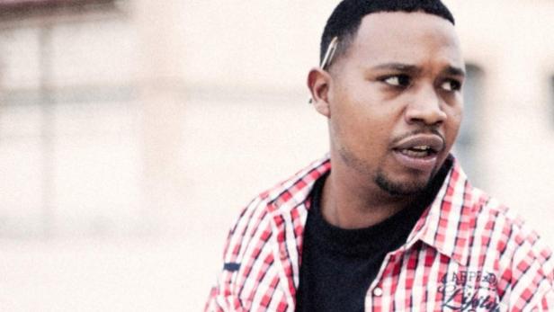 Ein Mann mit kariertem Hemd und Stift hinter dem Ohr schaut zur Seite.