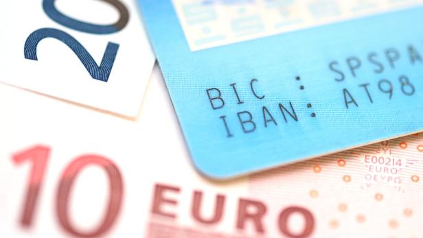 Nahaufnahme von Euroscheinen und einer Bankkarte mit IBAN und BIC.