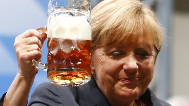 German Chancellor and top candidate for the Christian Democratic Union (CDU) Angela Merkel toasts with beer after her speech during an electoral rally in Dachau near Munich August 20, 2013. Merkel laid a wreath at Dachau concentration camp on Tuesday, making her the first German chancellor to visit the death camp where Nazis killed more than 41,000 people in the Holocaust. REUTERS/Michael Dalder (GERMANY - Tags: POLITICS ELECTIONS TPX IMAGES OF THE DAY)