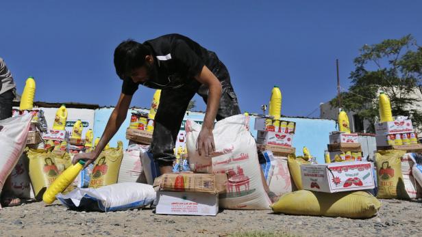 epa04931815 A Yemeni voluteer prepares family food rations provided by a local relief group, in Sanaía, Yemen, 15 September 2015. According to the UN World Food Programme (WFP), the number of food insecure people in Yemen is now close to 13 million, of a total population of 24 million, including 6 million who are severely food insecure and in urgent need of external assistance. EPA/YAHYA ARHAB