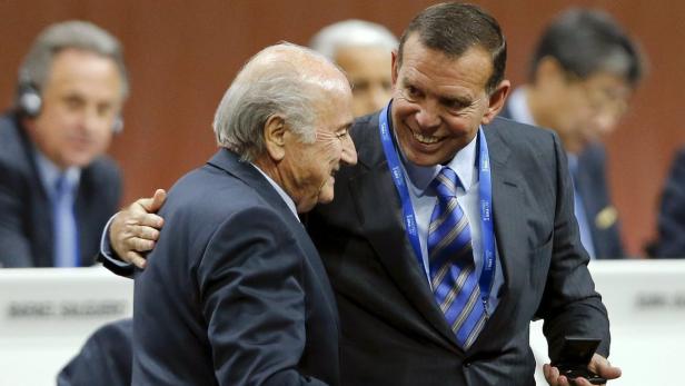 Sepp Blatter wird von einem Mann mit einer FIFA-Krawatte umarmt.