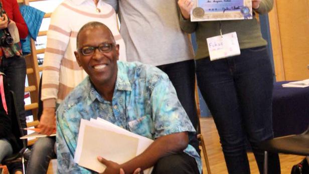 Eine Gruppe von vier Personen posiert mit einer Urkunde in einem Raum mit Sprossenwand.