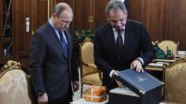 Präsident Putin und Verteidigungsminister Schoigu packen die Blackbox aus.