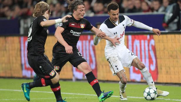 Ein Fußballspieler von Tottenham Hotspur kämpft um den Ball mit zwei Spielern von Bayer Leverkusen.