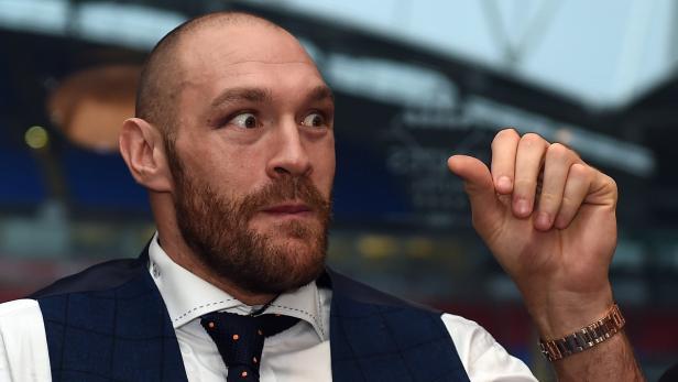 Tyson Fury mit Bart und Weste gestikuliert mit der Hand.
