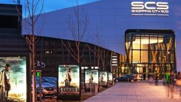 Das SCS Shopping City Süd Einkaufszentrum bei Nacht mit Werbeplakaten für den Film „Exodus“.
