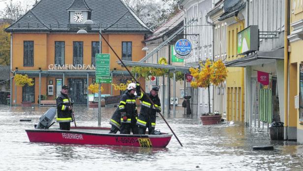 Feuerwehrleute in einem Boot während einer Überschwemmung in einer Stadt.