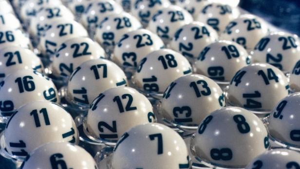 Nahaufnahme von nummerierten Lottokugeln in ihren Halterungen.