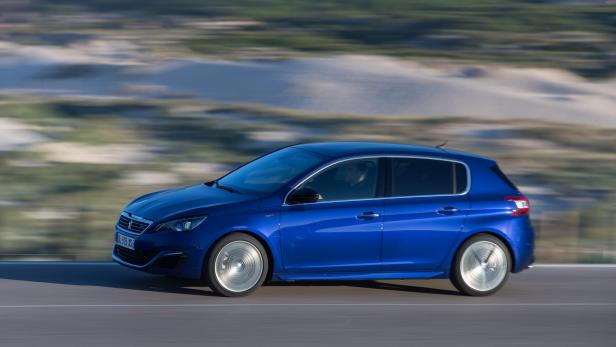 Ein blauer Peugeot 308 fährt auf einer asphaltierten Straße.