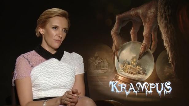 Toni Collette vor einem Poster für den Film „Krampus“.