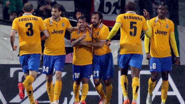 Mehrere Juventus-Spieler in gelben Trikots feiern ein Tor.