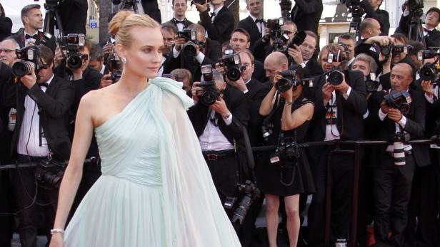 Diane Kruger posiert in einem hellblauen Kleid vor einer Wand aus Fotografen.