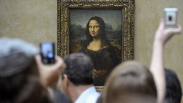 Besucher fotografieren Leonardo da Vincis „Mona Lisa“ im Louvre.
